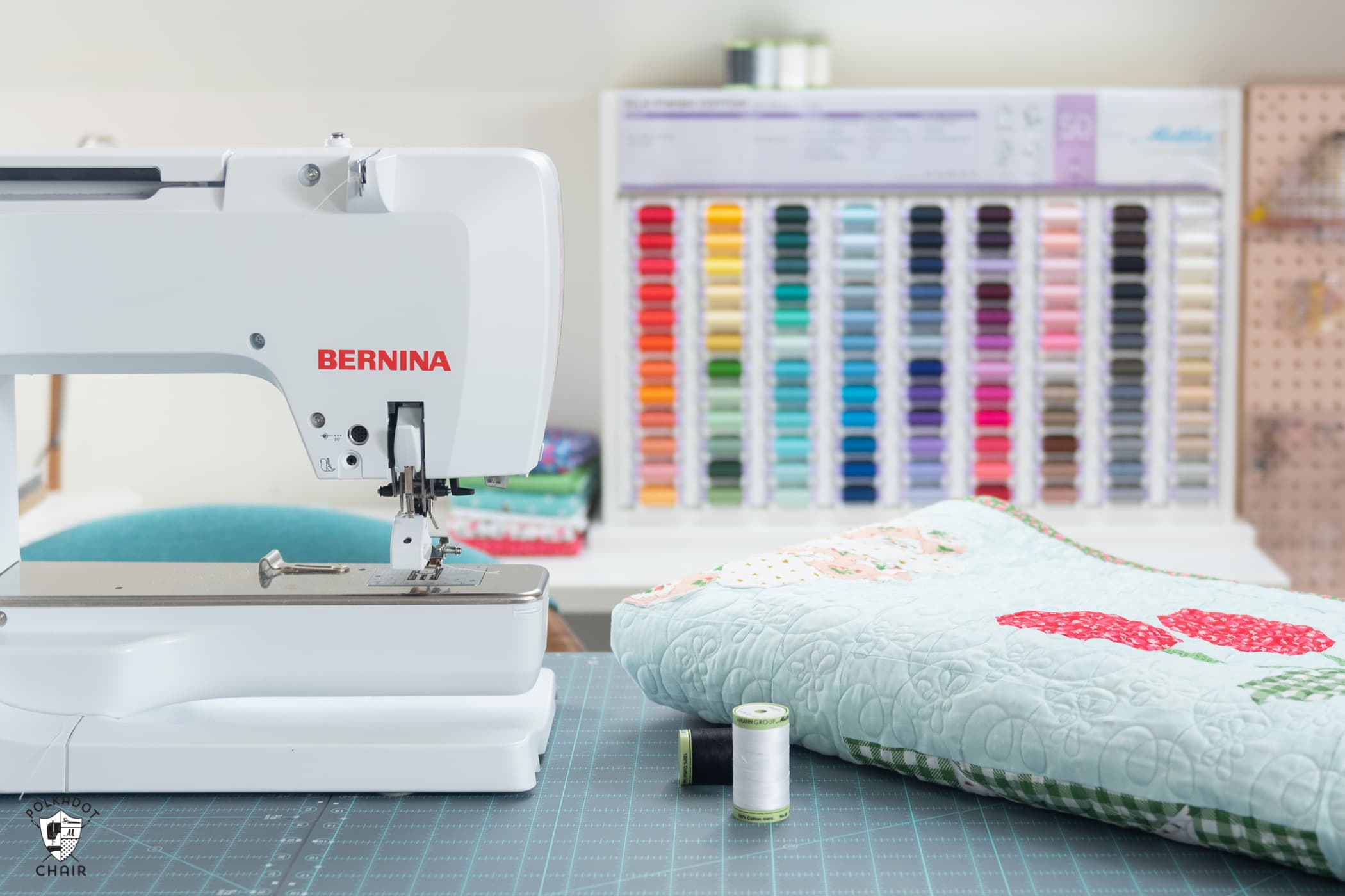 quilt, thread and sewing machine on table