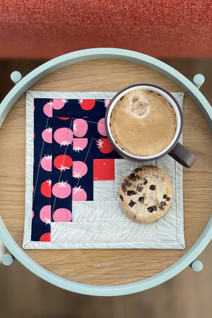 navy and ivory log cabin mug rug on wood tray with coffee and cookie