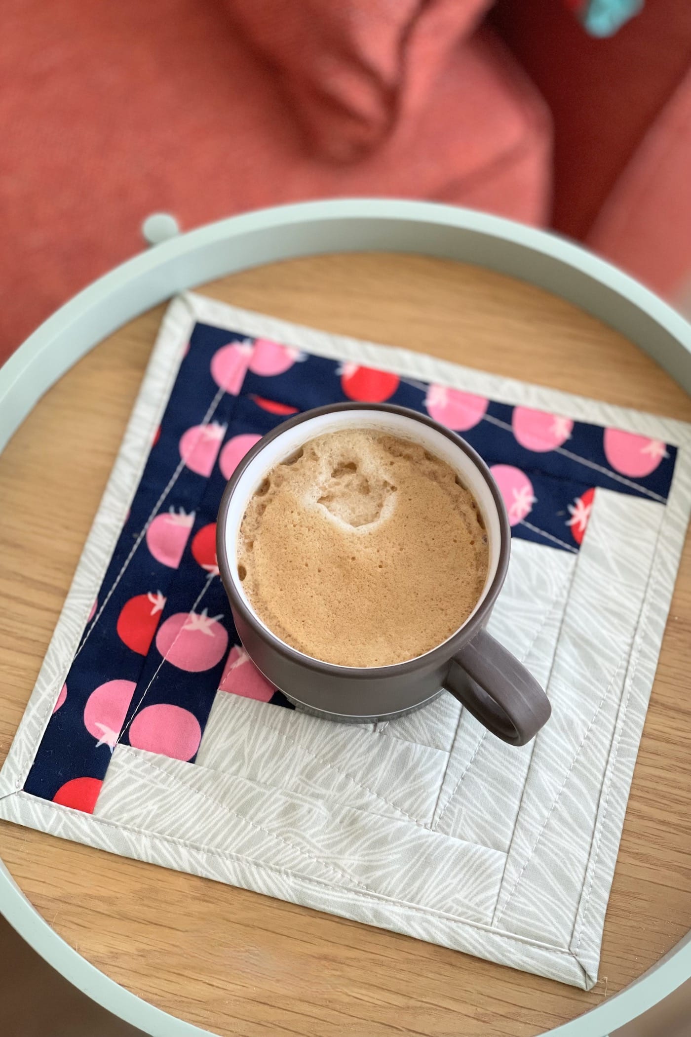 navy and ivory log cabin mug rug on wood tray with coffee and cookie