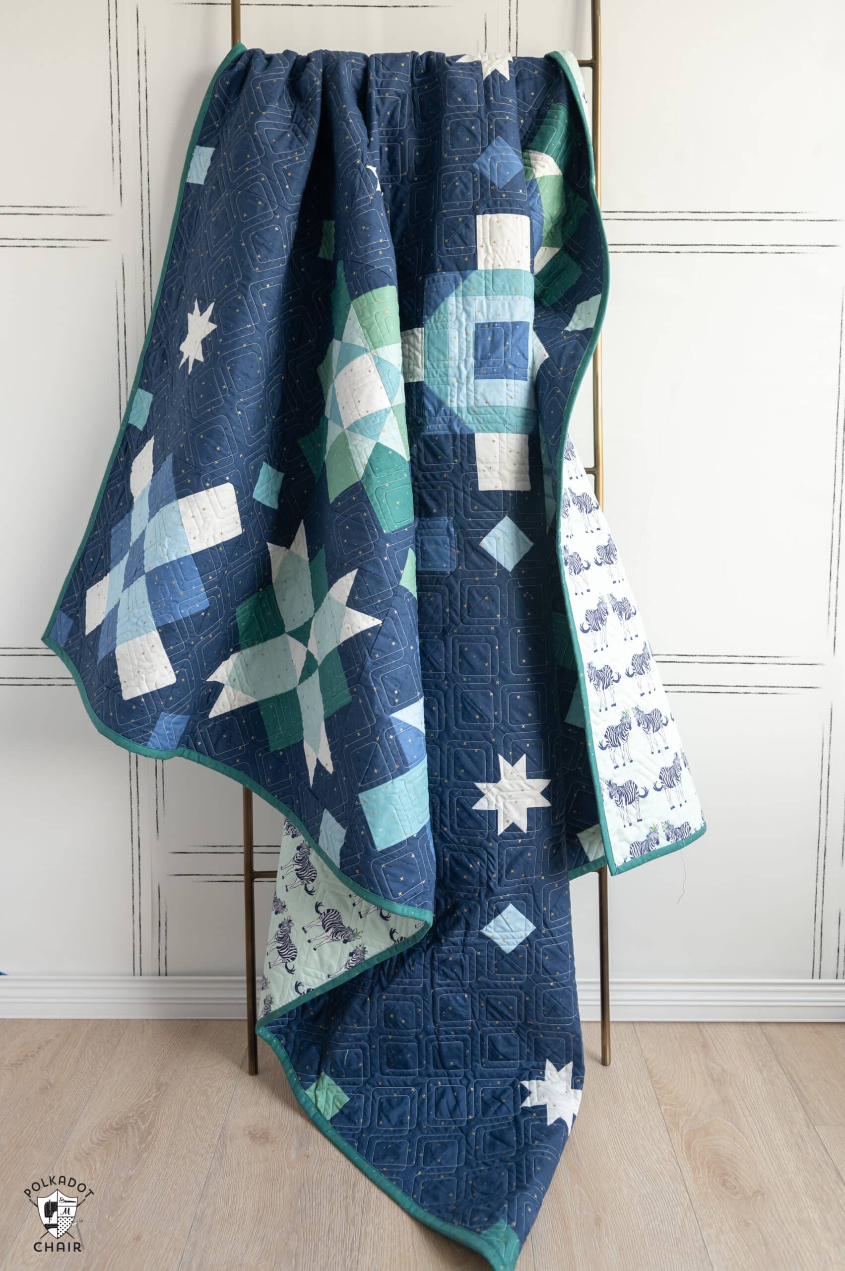 navy, blue and green quilt made from squares and rectangles - a modern granny square quilt pattern on ladder in white room
