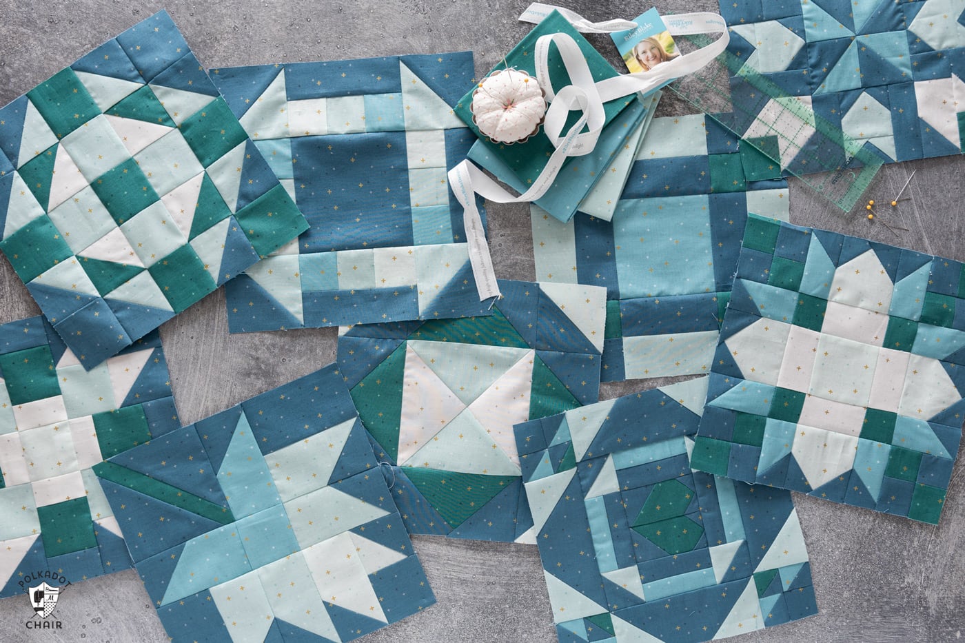 multiple blue and green quilt blocks on gray table