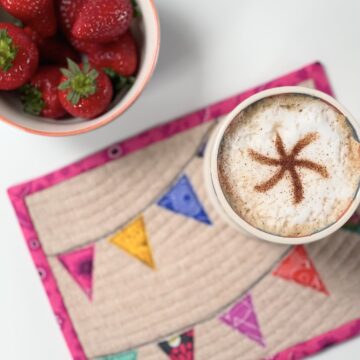 colorful mug rug and coffee cup on tabletop