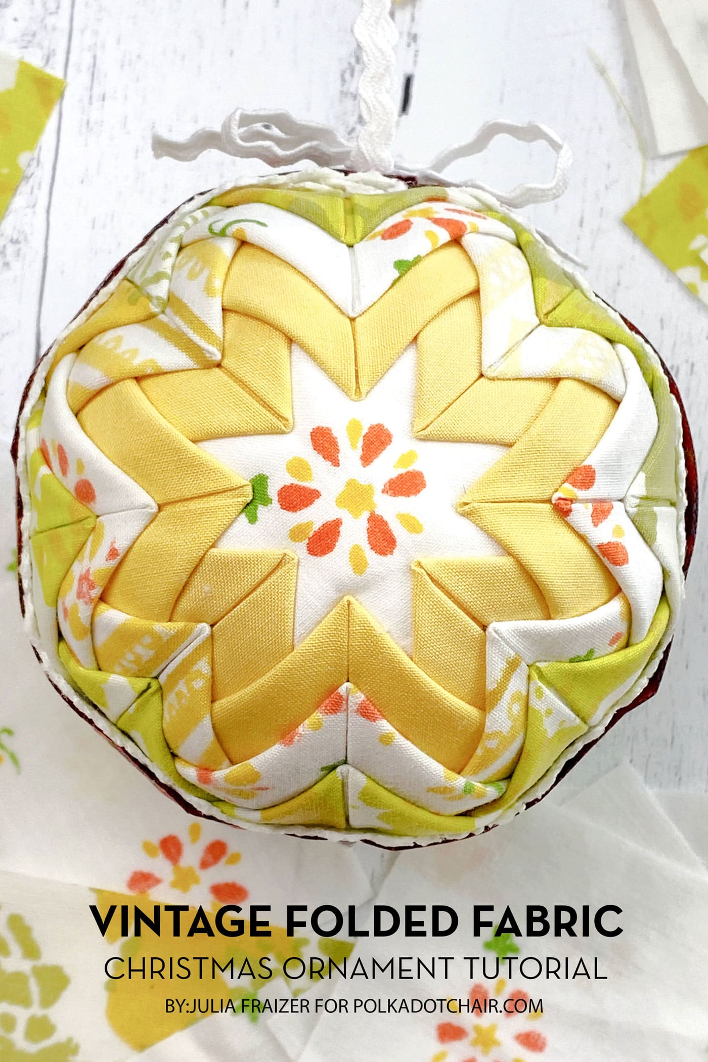 yellow and white vintage folded fabric ornament on white table with fabric scraps