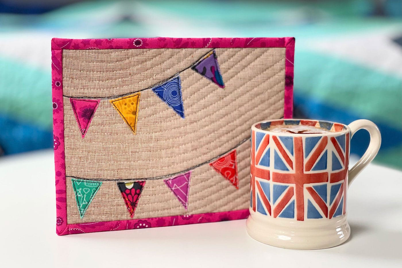 colorful mug rug and union jack mug on white tabletop