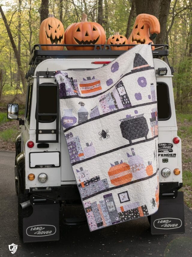 Halloween quilt and vintage Land Rover with pumpkins outdoors