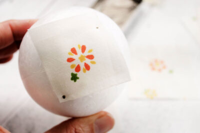 white fabric with flower, yellow folded fabric and styrofoam ball in various stages of construction