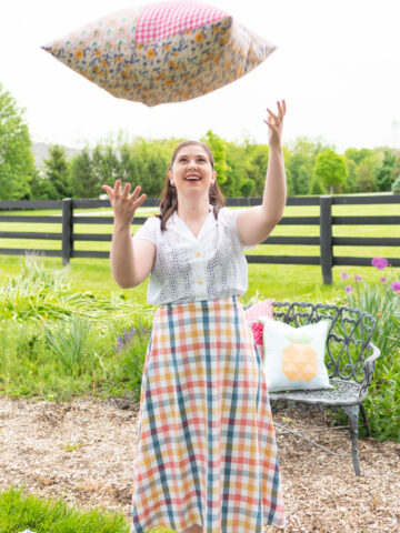 girl throwing giant pillow outdoors
