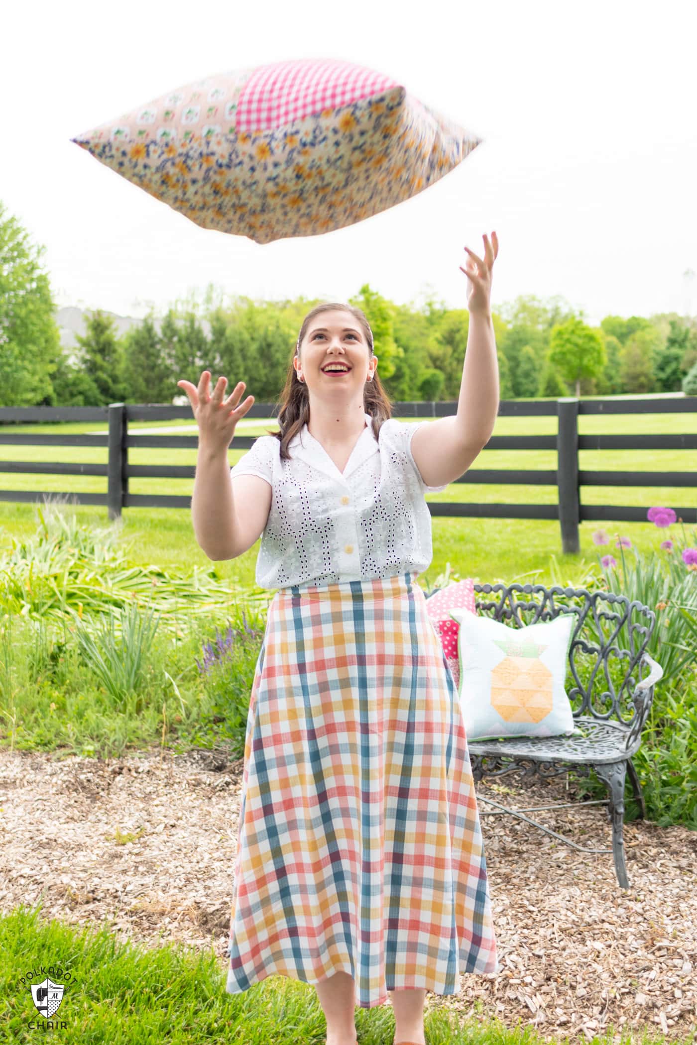 girl throwing giant pillow outdoors