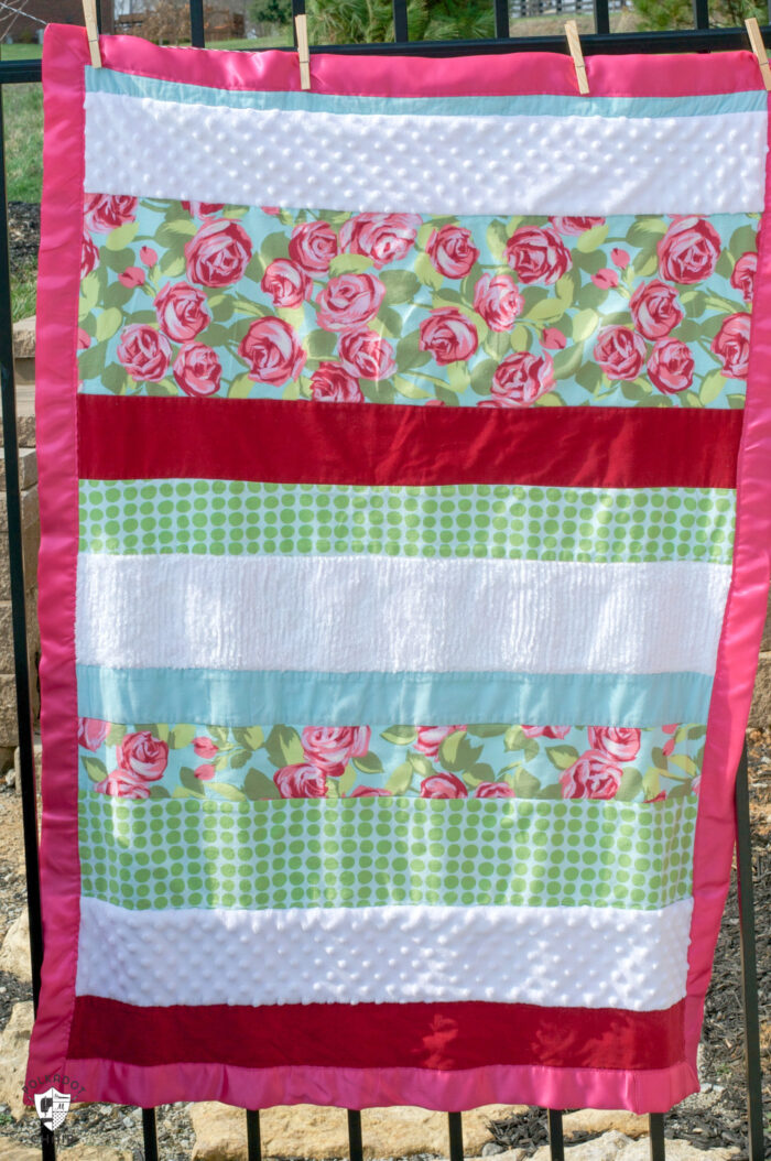 striped textured baby quilt on fence outdoors