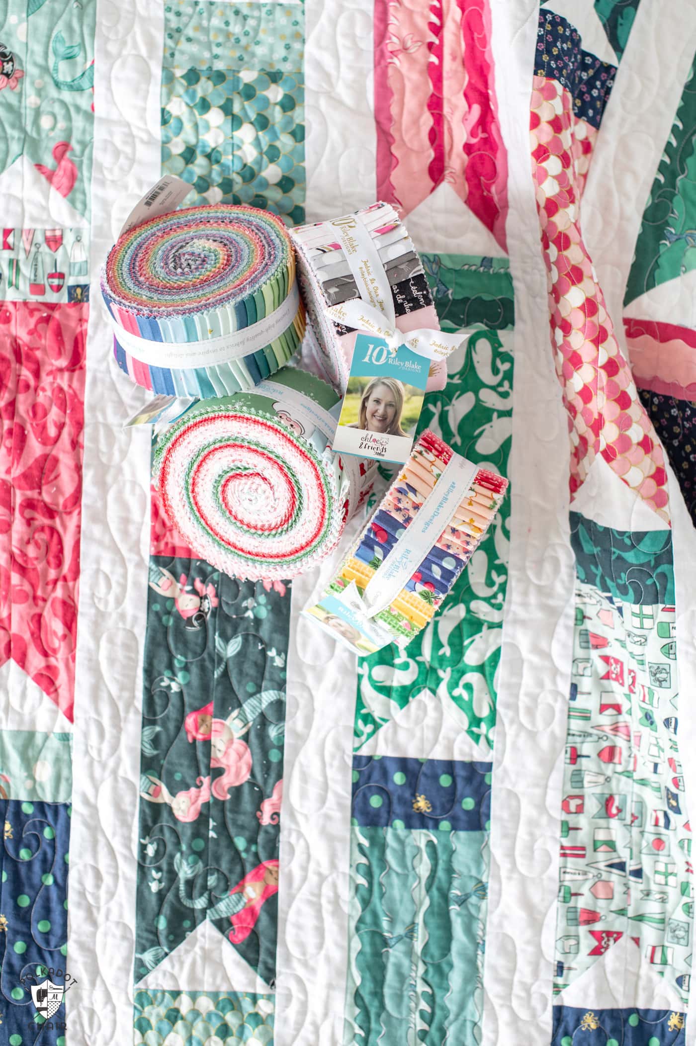 precut rolls of fabric on top of colorful quilt