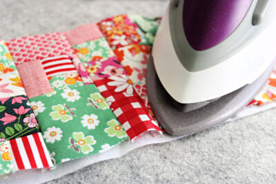 iron and colorful fabric scraps on table