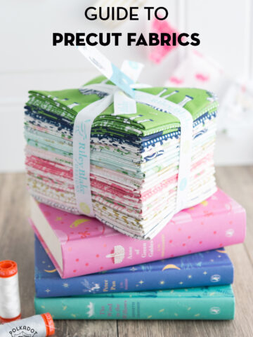 stack of precut fabrics on books