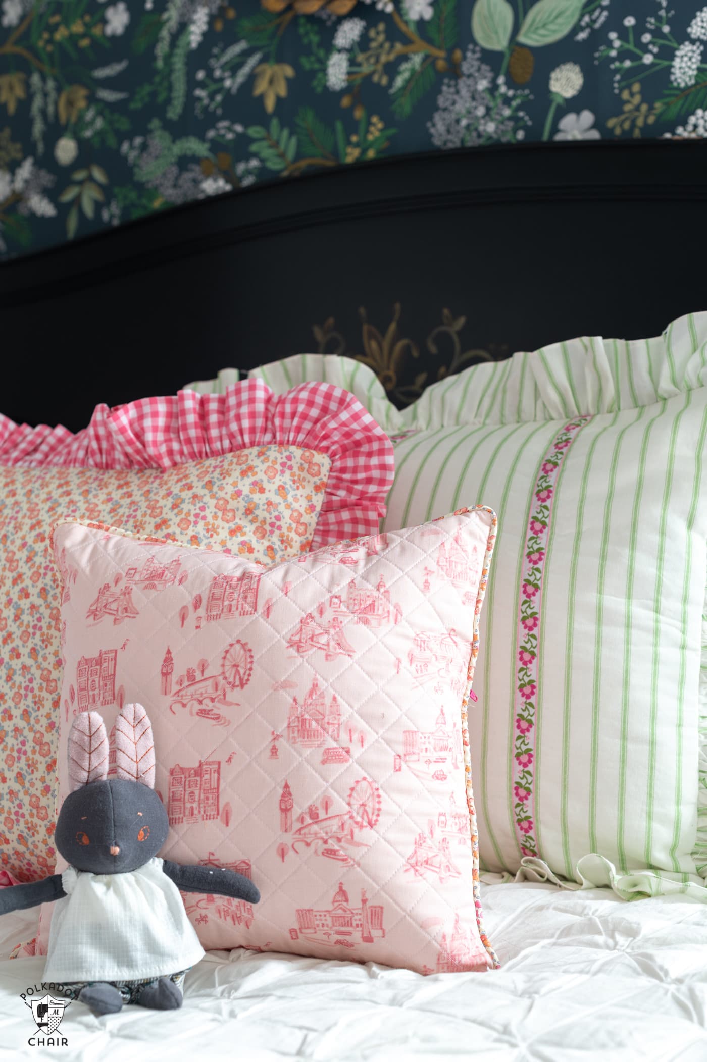 trio of pink and green pillows on the bed