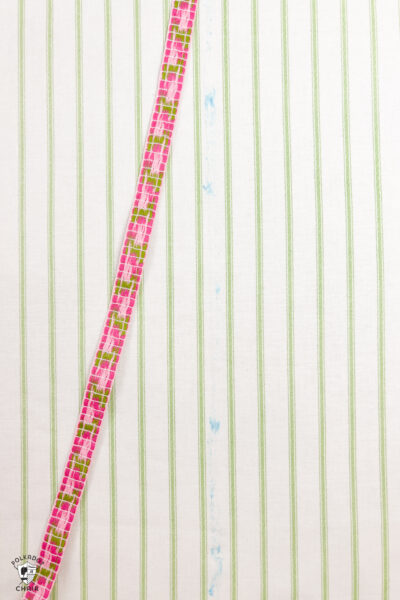pink trim with glue on back on top of striped fabric