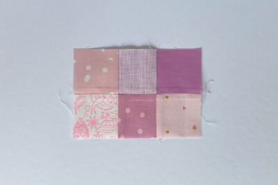 squares of pink fabric sewn together on white tabletop