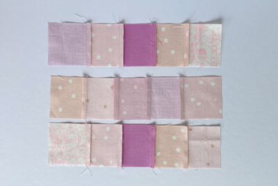 squares of pink fabric sewn together on white tabletop