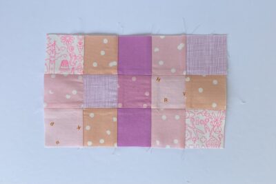 squares of pink fabric sewn together on white tabletop