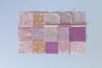 squares of pink fabric sewn together on white tabletop