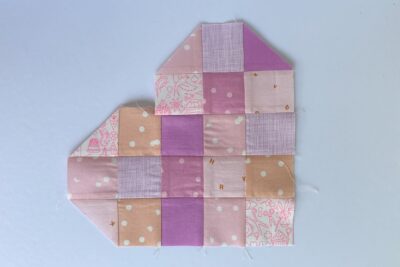 squares of pink fabric sewn together on white tabletop