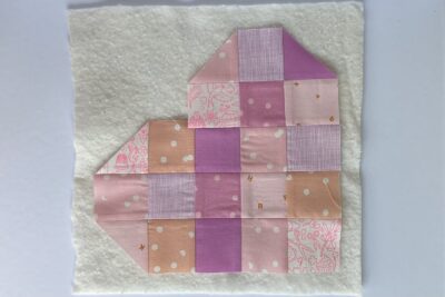 squares of pink fabric sewn together on white tabletop
