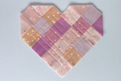 squares of pink fabric sewn together on white tabletop