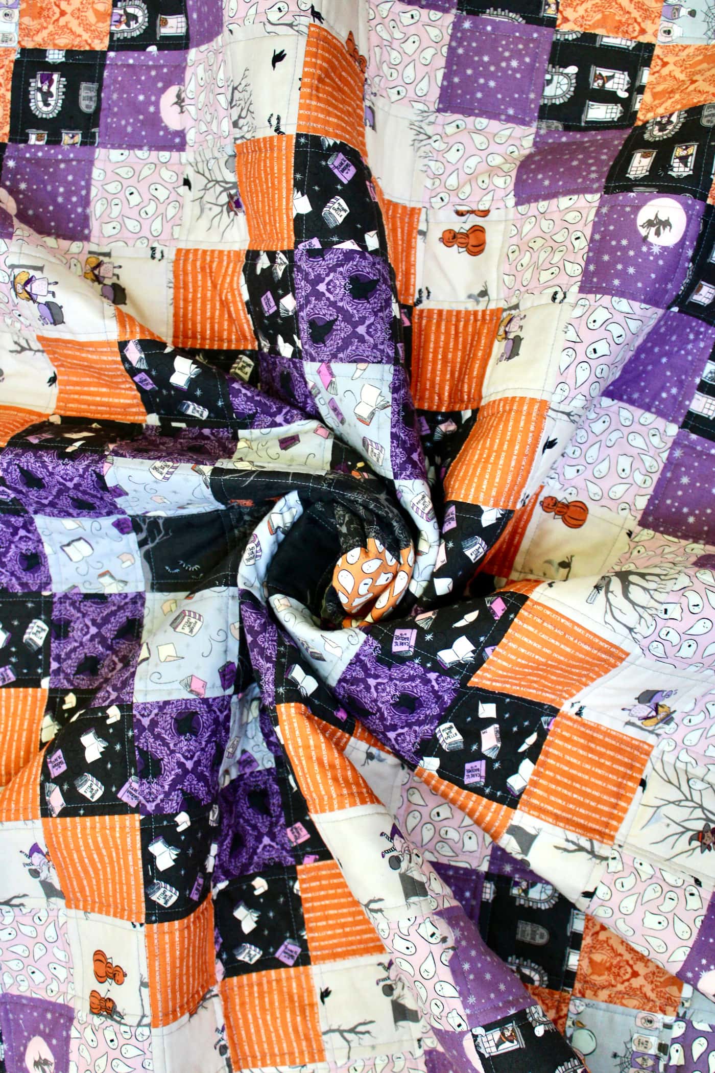 black, orange and purple patchwork quilt outside