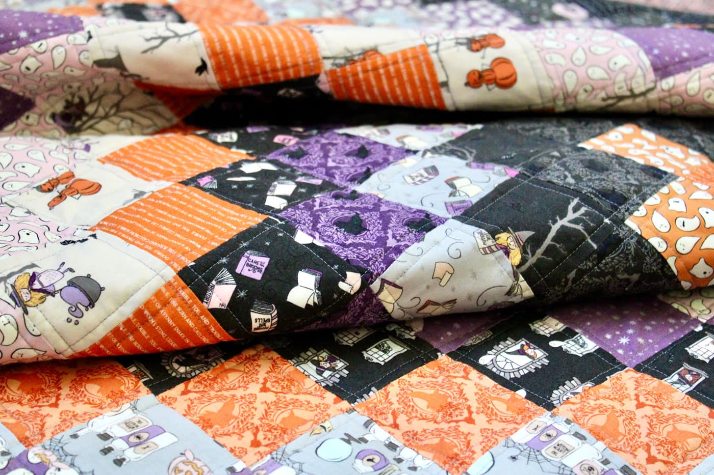 close up of black, orange and purple patchwork quilt outdoors