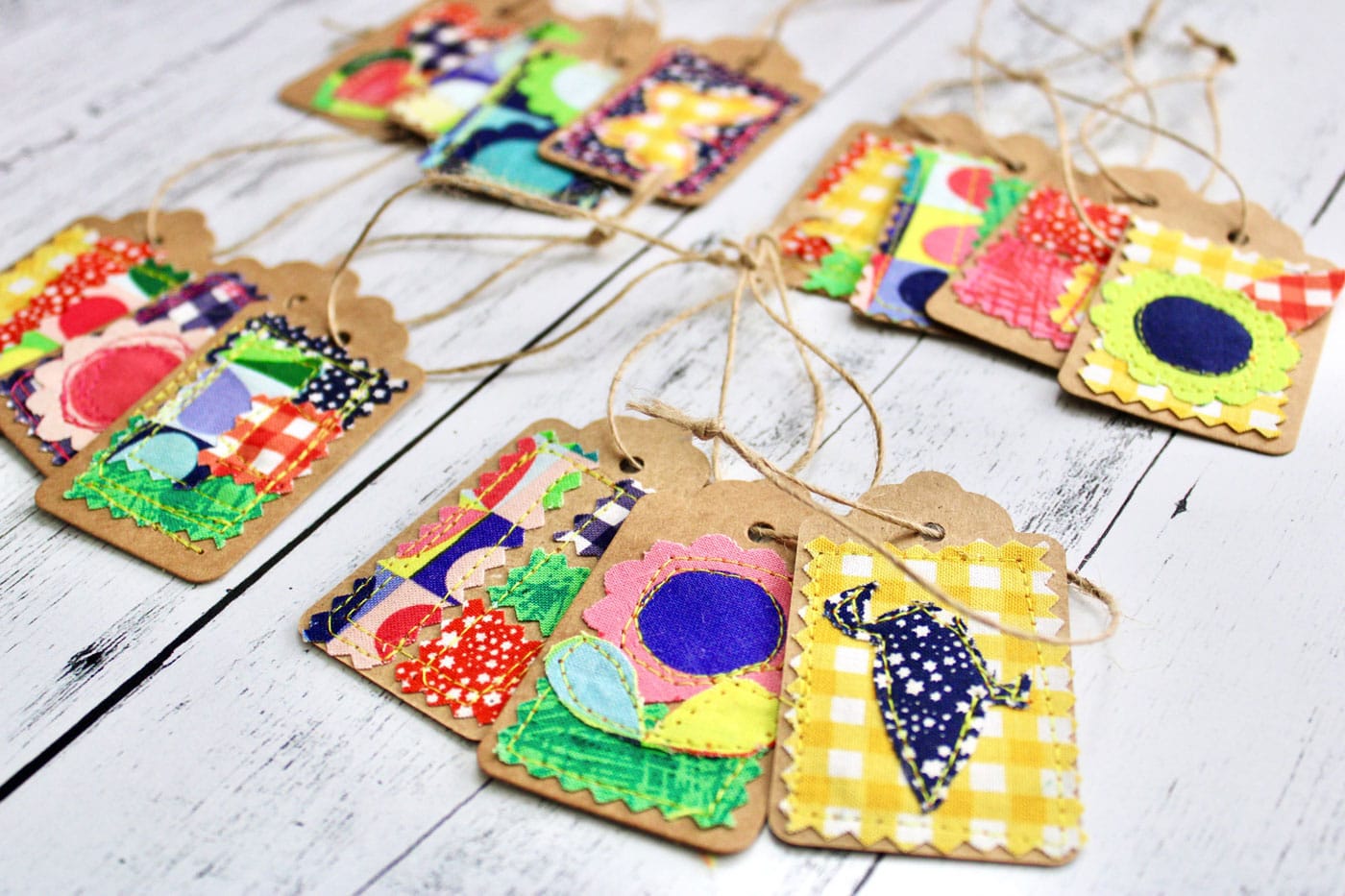 colorful fabric and paper gift tags on white wood table