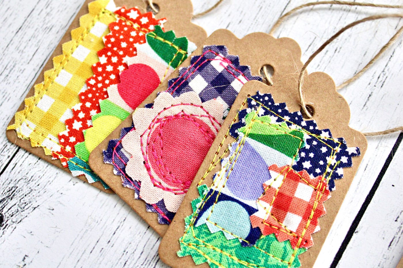 colorful fabric and paper gift tags on white wood table