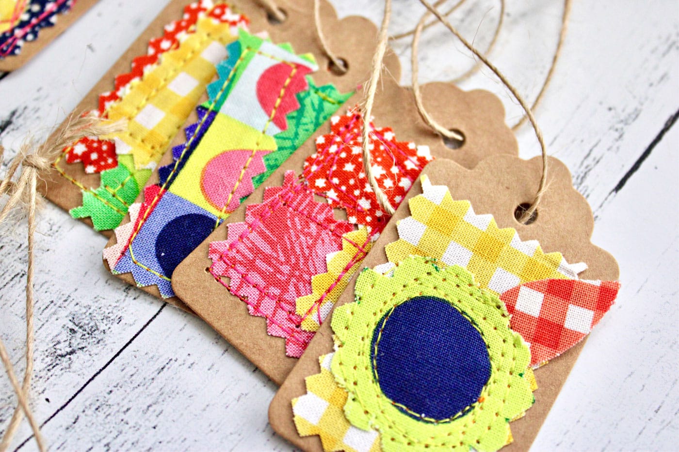 colorful fabric and paper gift tags on white wood table