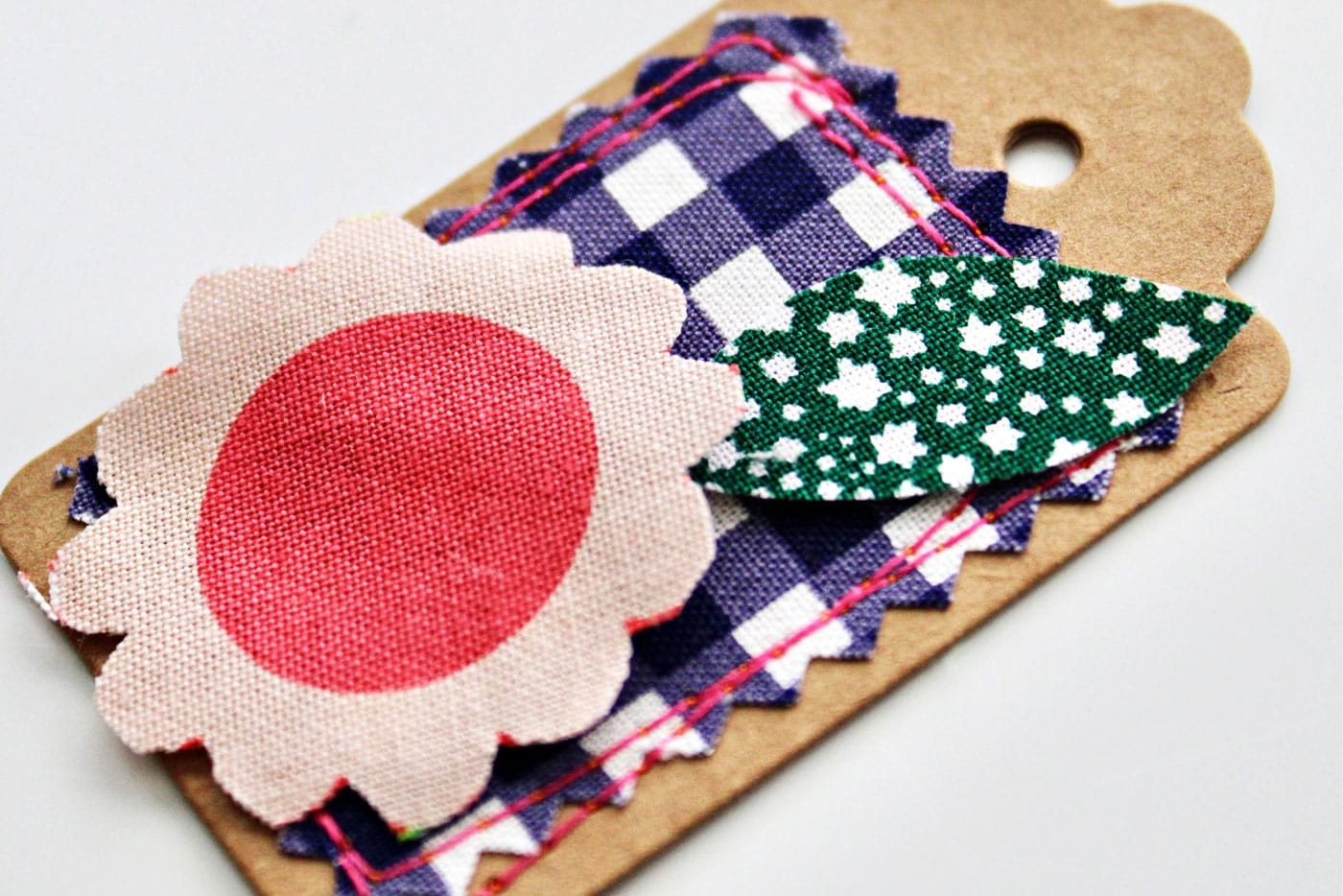 colorful fabric and paper gift tags on white wood table