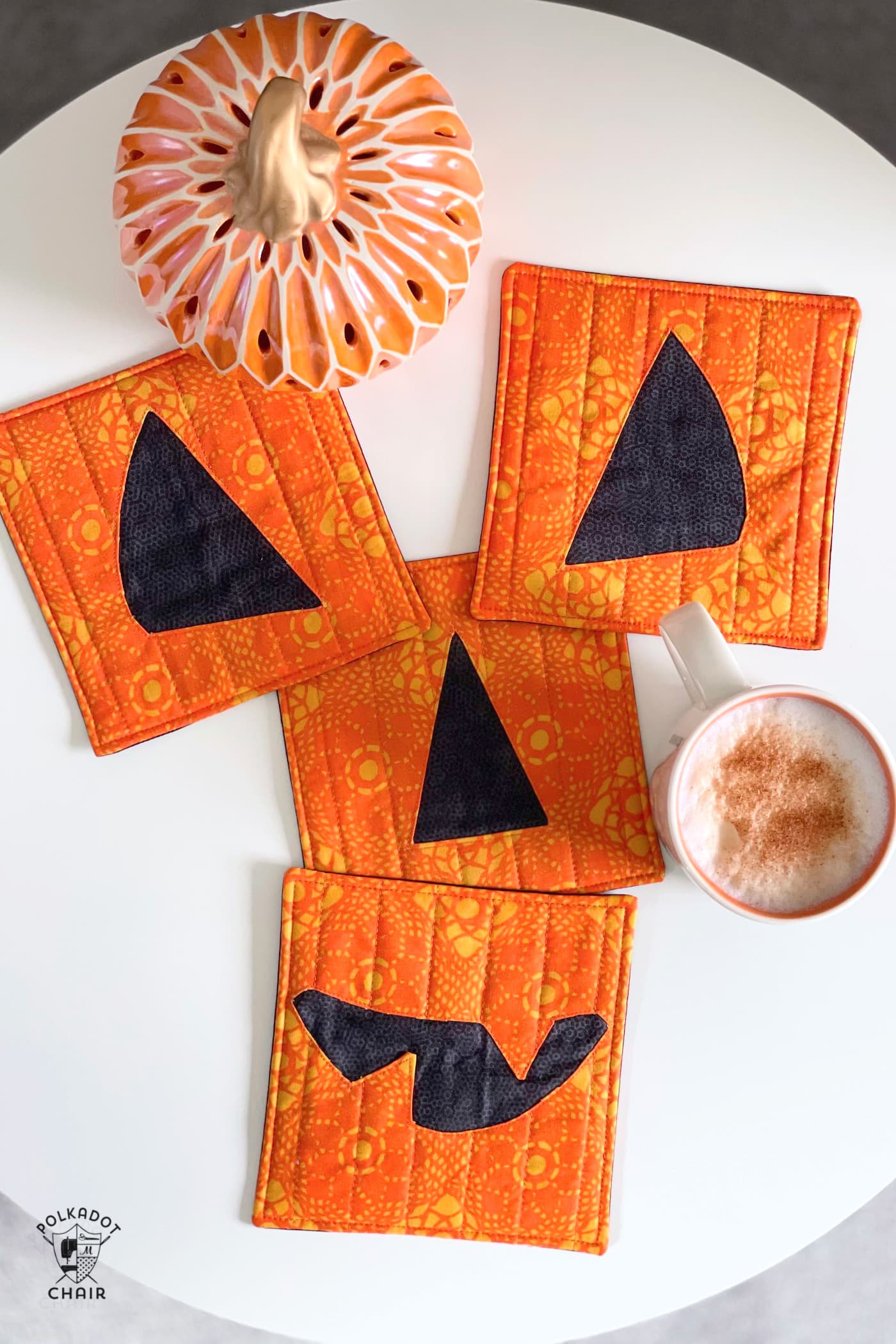 pumpkin face mug rug on white table with coffee cups