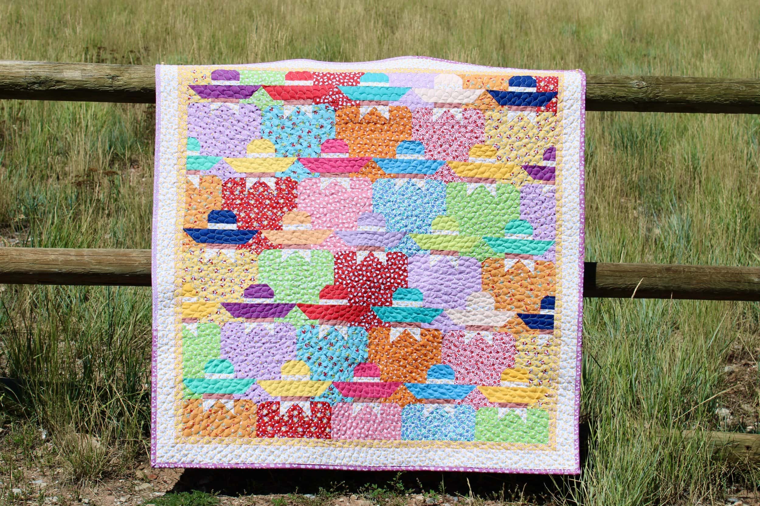 quilt hanging on wood fence