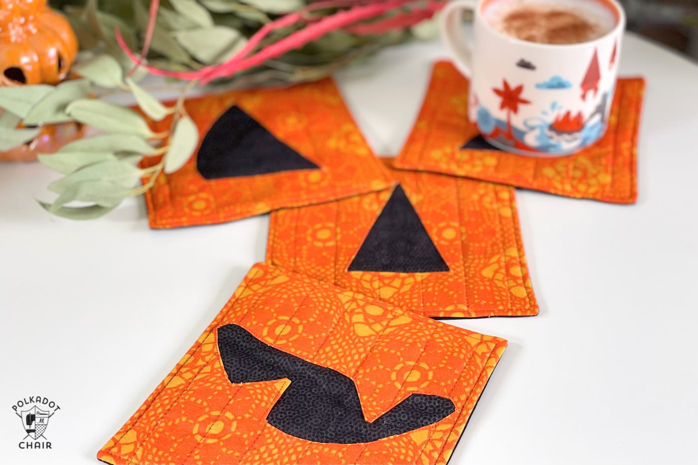 pumpkin face mug rug on white table with coffee cups