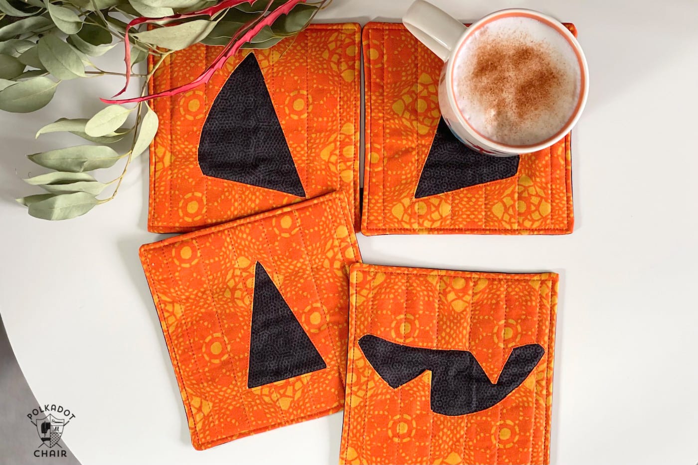 pumpkin face mug rug on white table with coffee cups