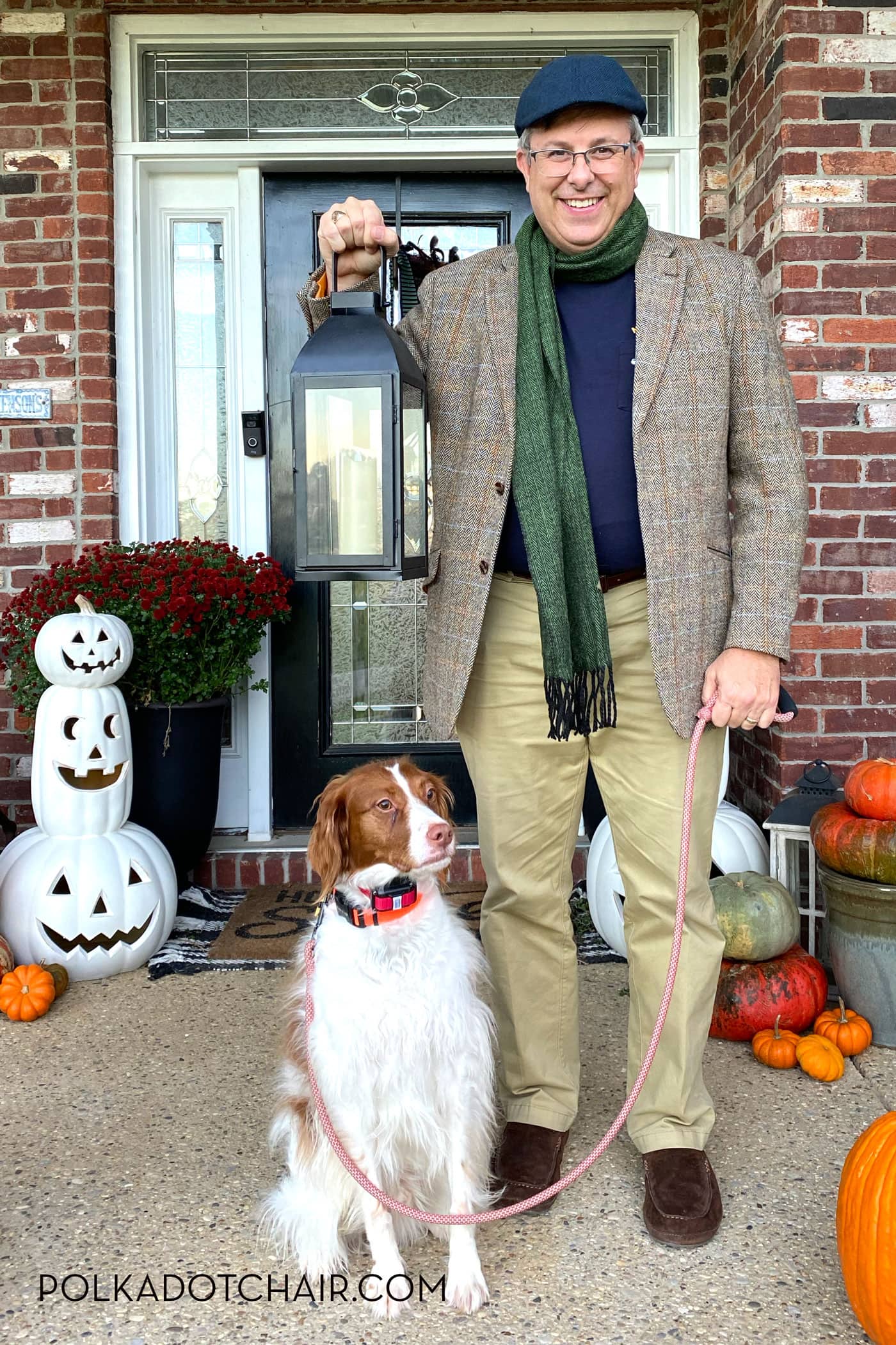 man dressed up as groundskeeper with dog on front porch