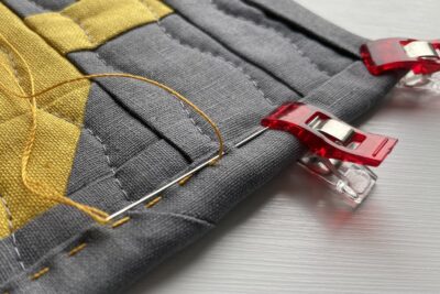 close up of yellow stitching thread and binding clip