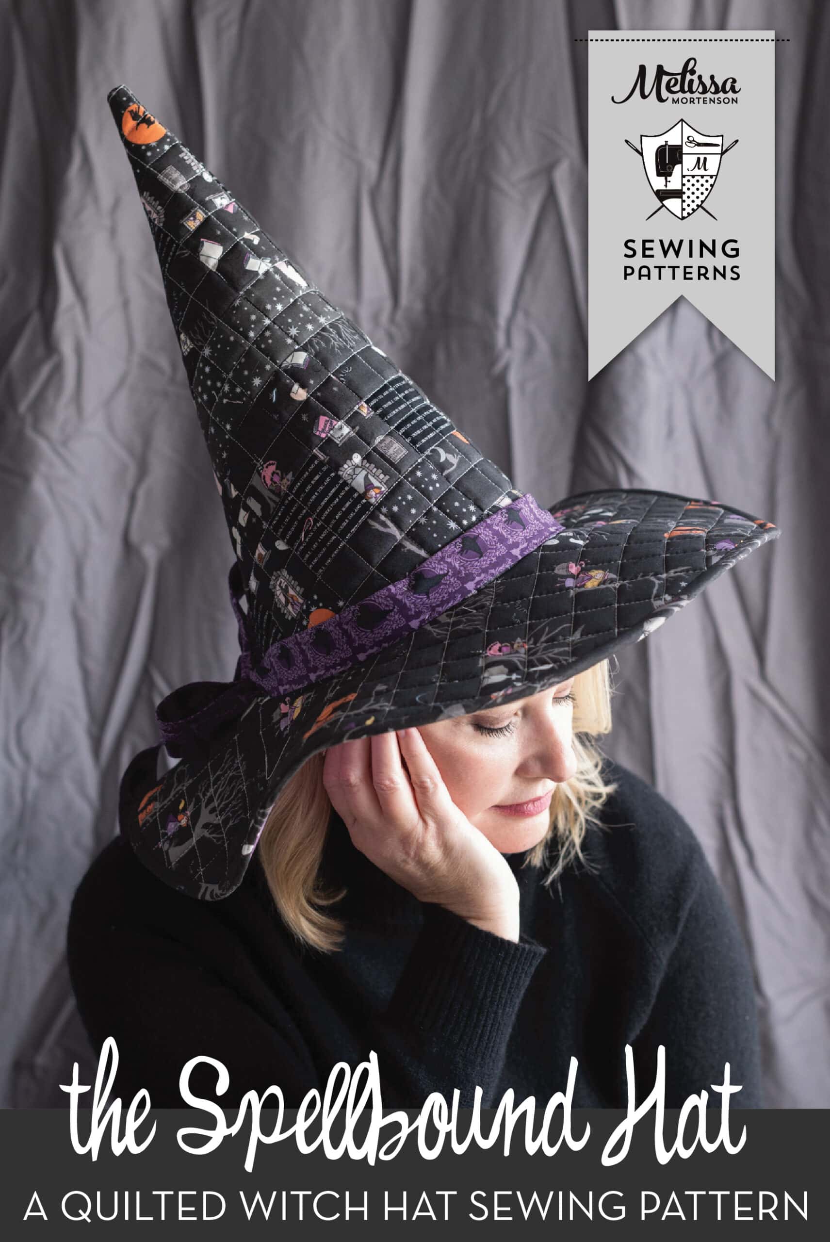 woman wearing patchwork witch hat in front of gray wall