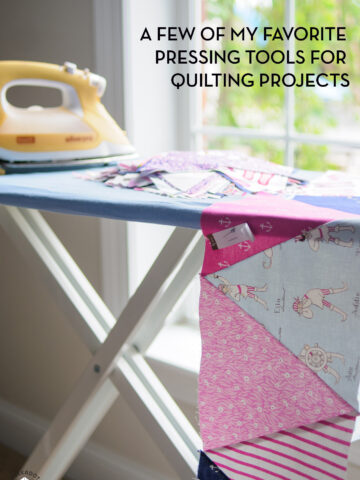 iron and ironing board near window with fabric