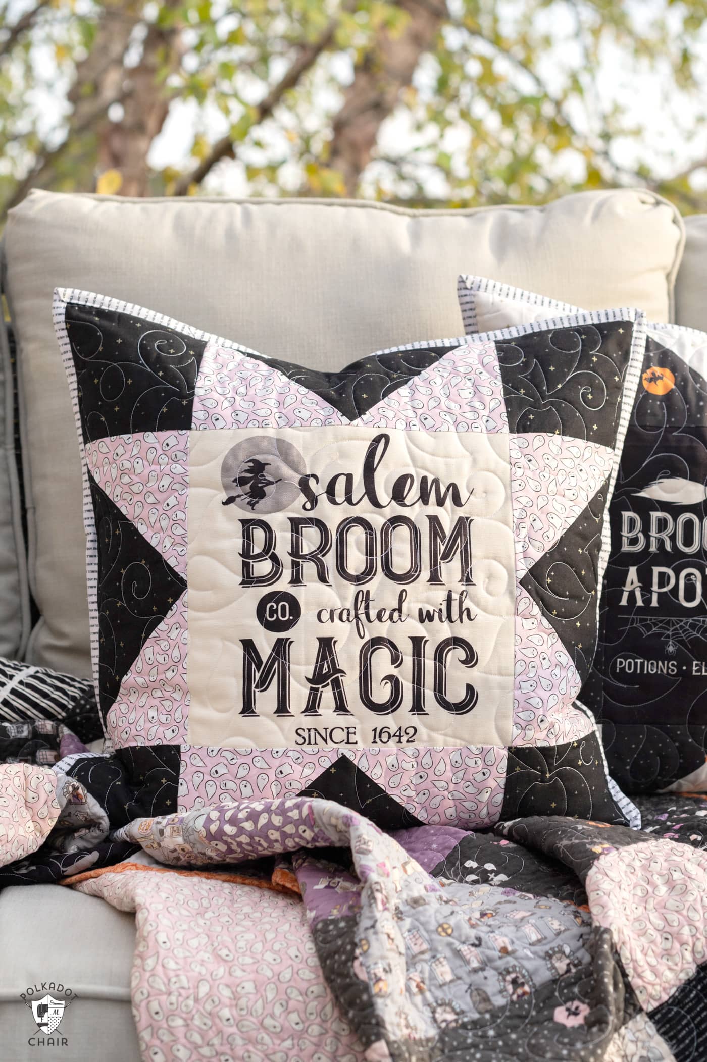 two black and white pillows on couch outdoors with halloween quilt