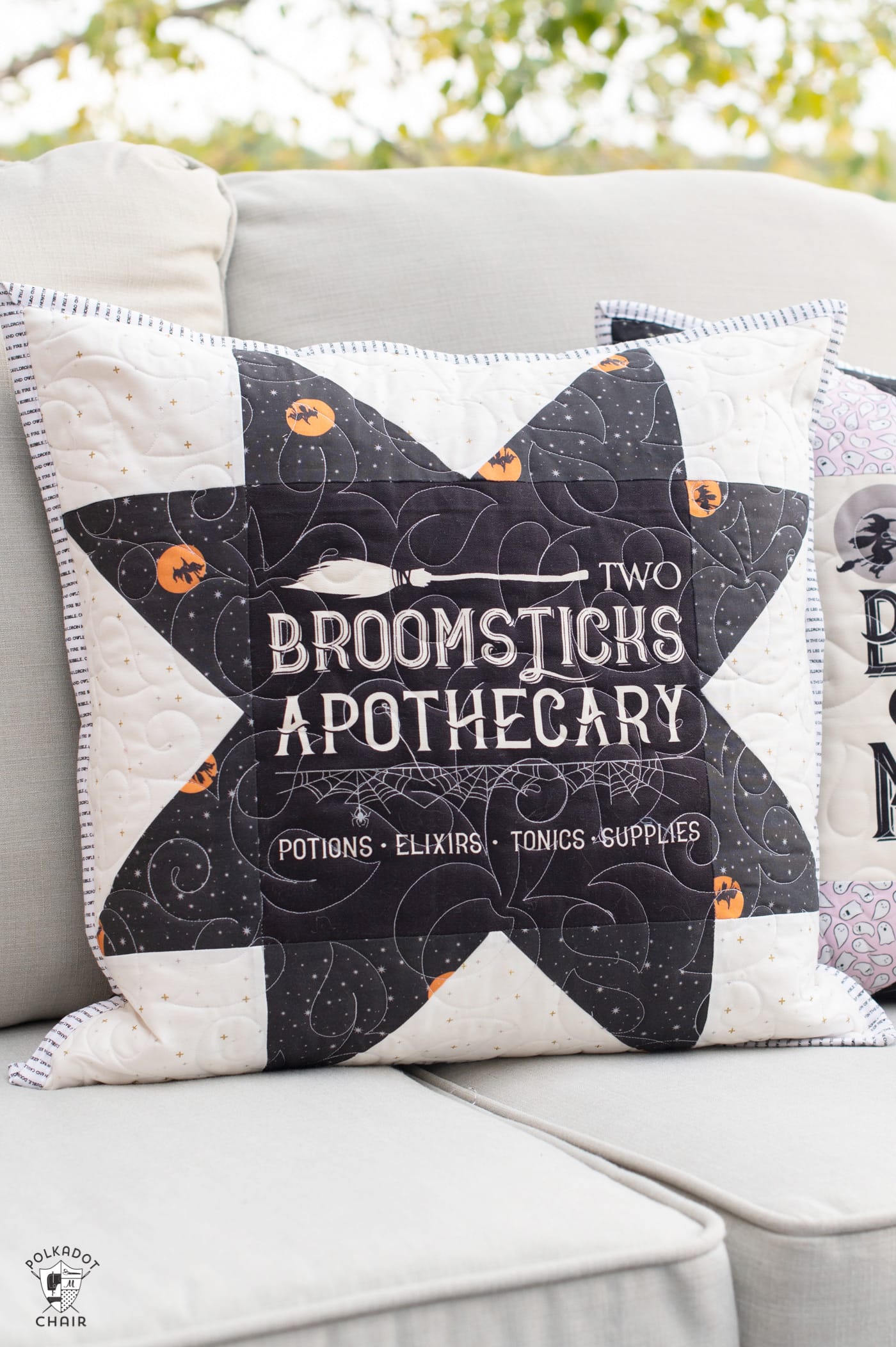 two black and white pillows on couch outdoors with halloween quilt