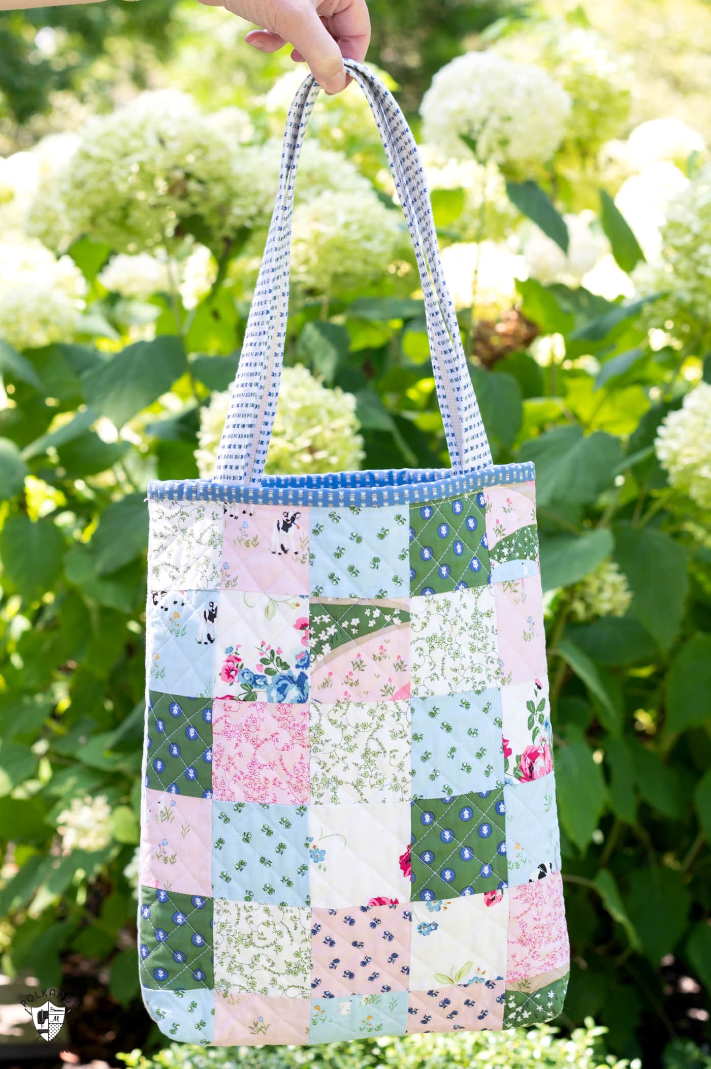 woman in blue and white dress holding bag