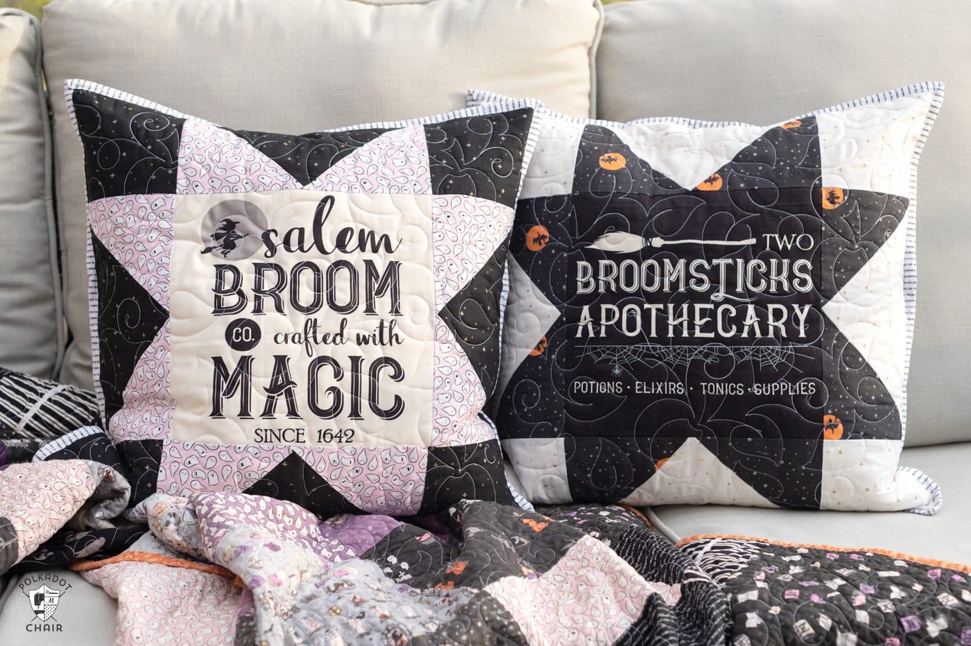 two black and white pillows on a couch outside with a Halloween quilt