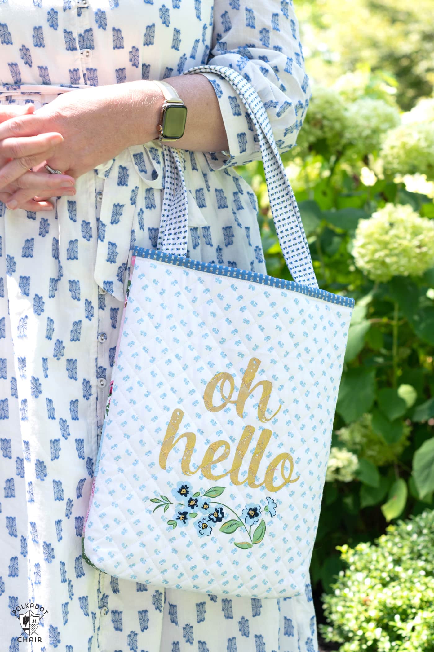 woman in blue and white dress holding bag