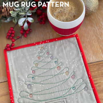 gray and red mug rug on wood table with coffee cup and christmas decorations