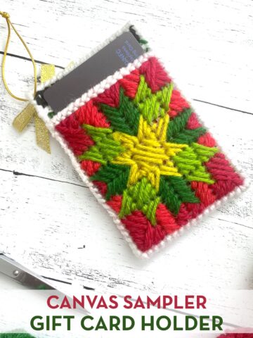 red, green and yellow plastic canvas gift card holder on white wood table