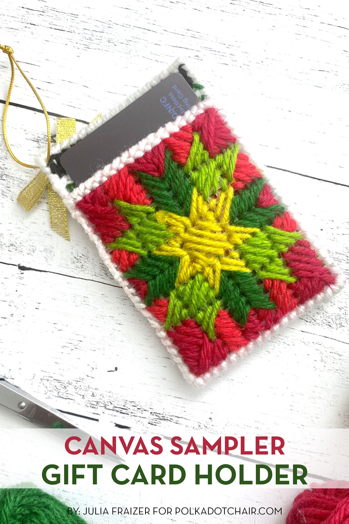 red, green and yellow plastic canvas gift card holder on white wood table
