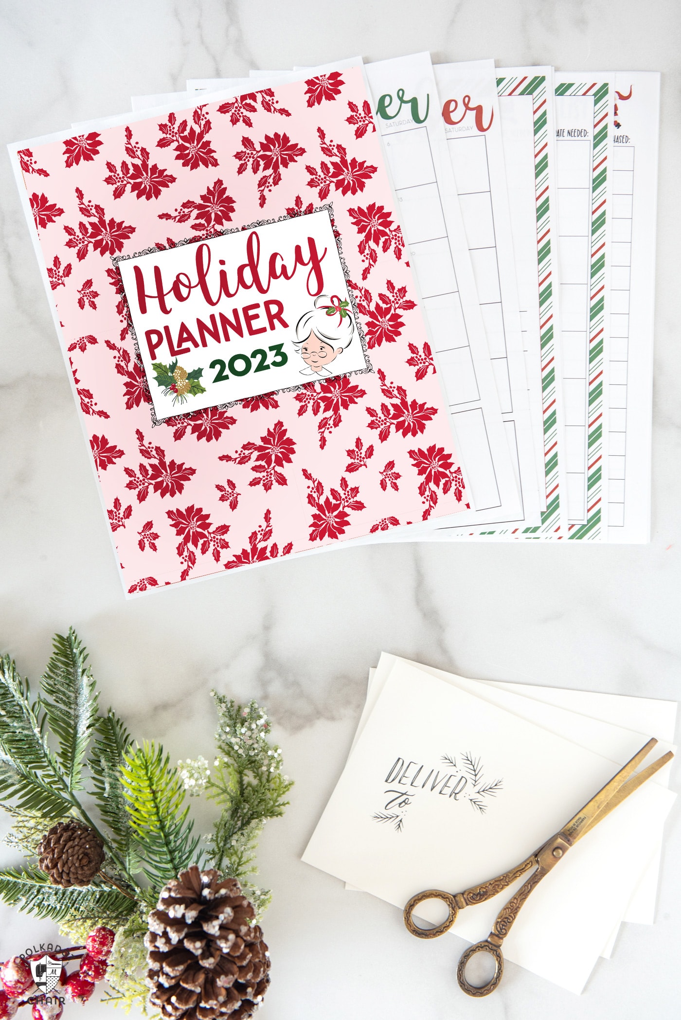 Christmas planning pages on white marble table with pencils