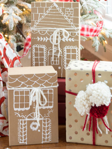 paper gingerbread house gift boxes in front of christmas tree