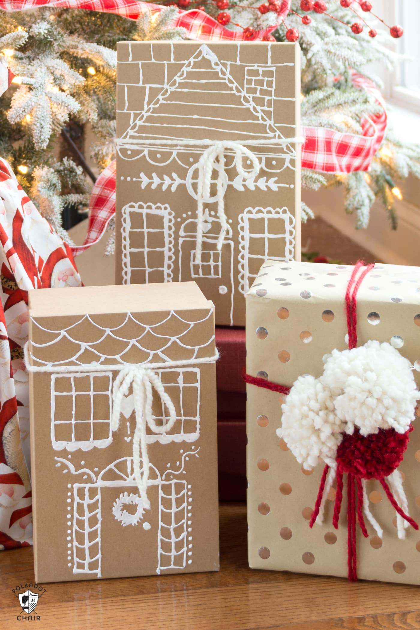 paper gingerbread house gift boxes in front of christmas tree